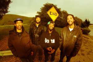 Souls of Mischief line up against the side of the road and an END sign